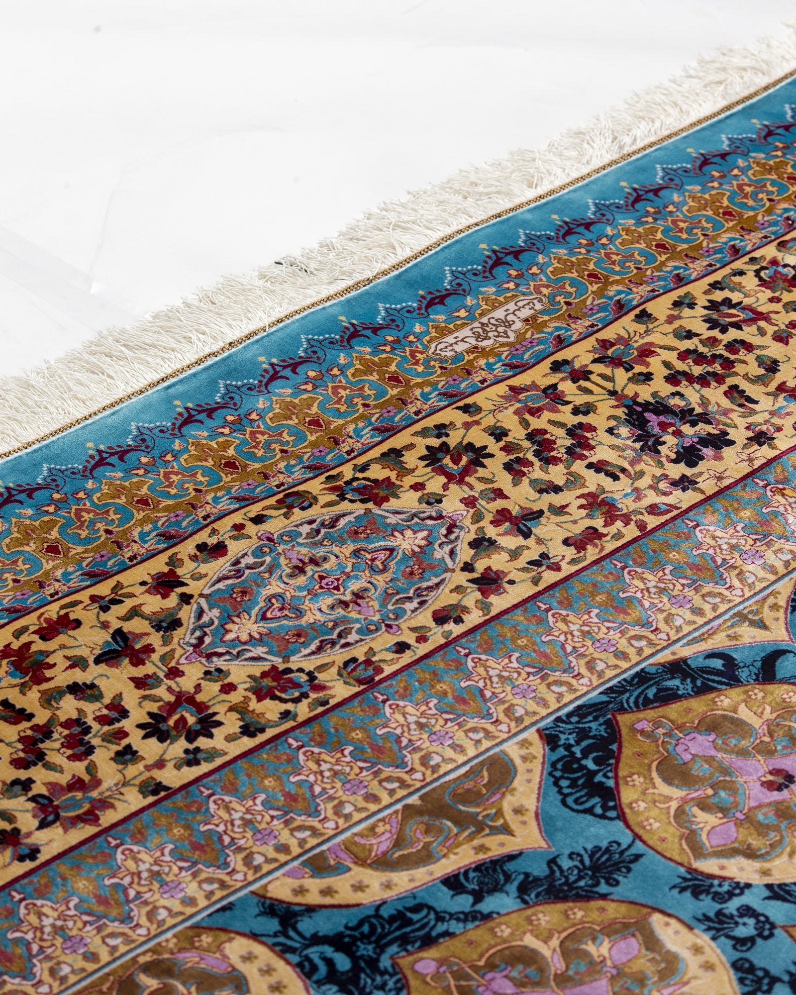Ophira Persian silk rug folded corner showing fine weave, turquoise and gold 250 x 350 cm - Tabeer Homes Dubai