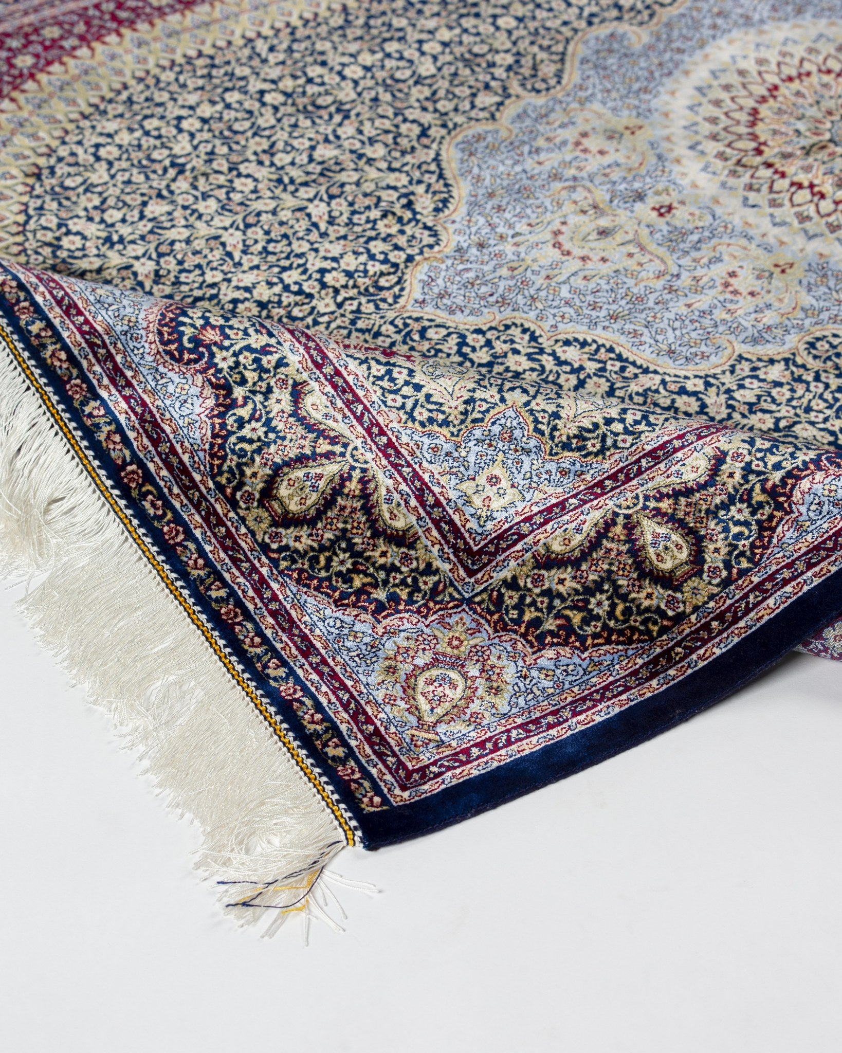 Angled view of the Roya silk rug with fringed end