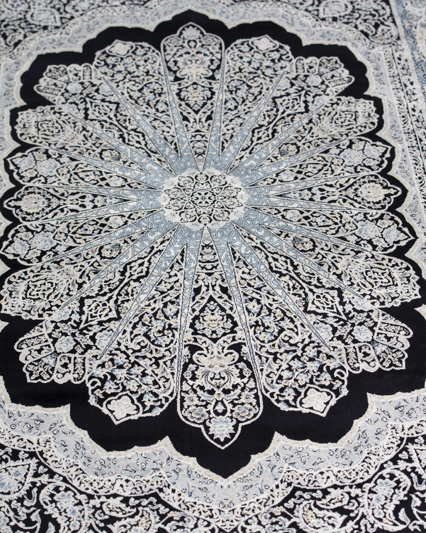 Close view of the Shabnam silk rug starburst medallion in silver on black