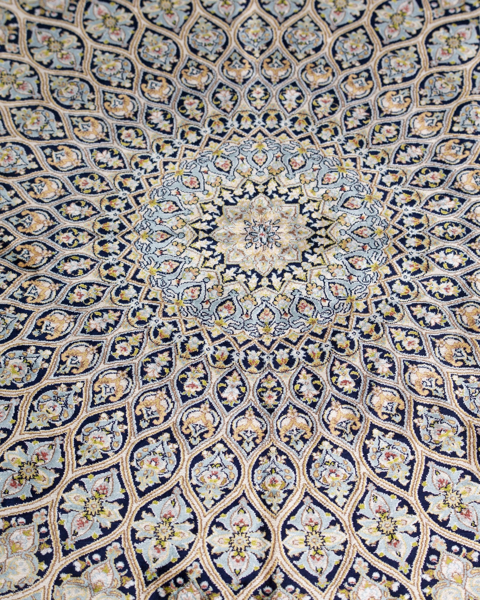 Angled view of the Sitareh silk rug with fringed end