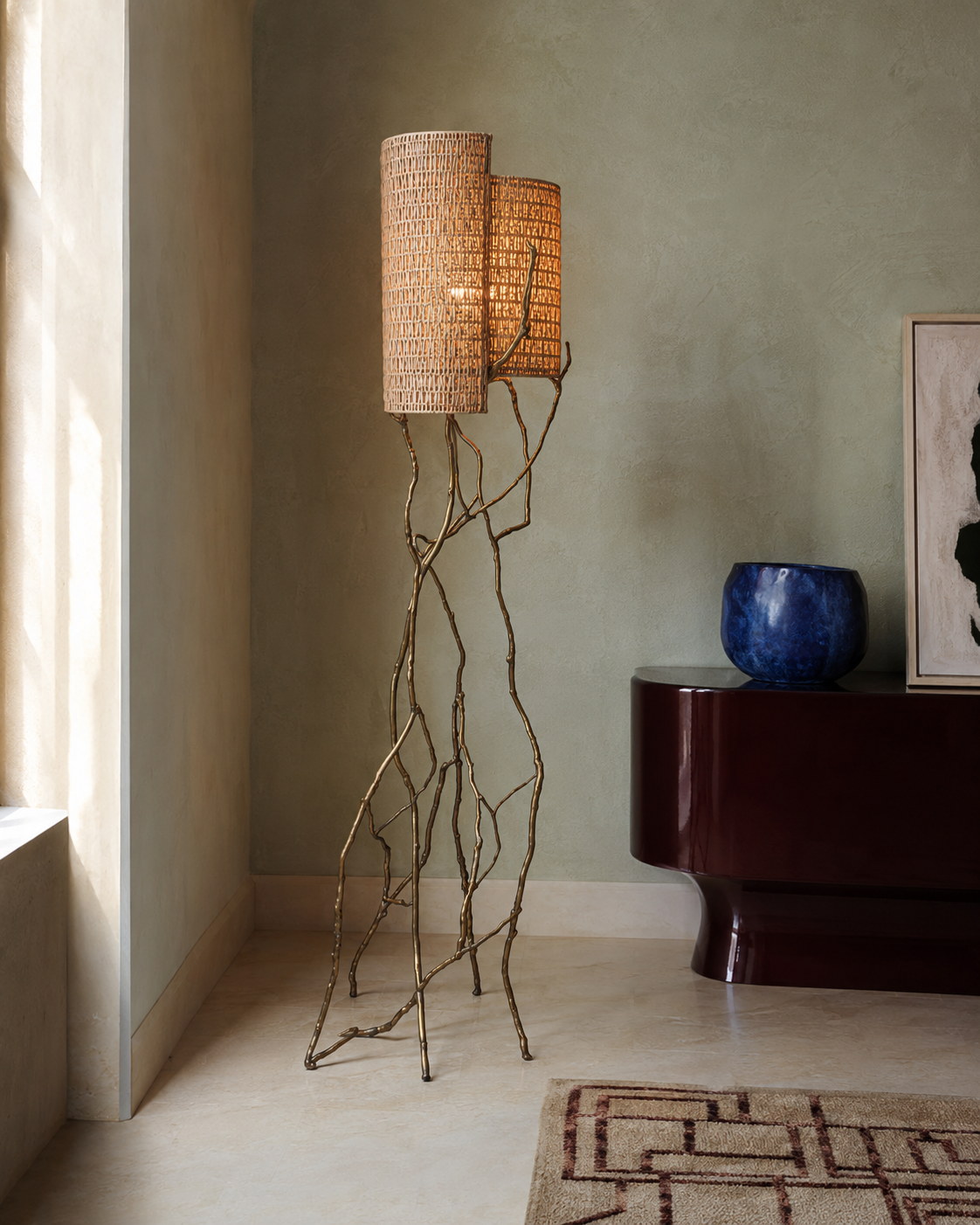 The Banyan Floor Lamp by The Qratist features a sculptural patinated gold brass frame inspired by banyan tree roots with handcrafted woven cane shades, creating a warm and elegant nature inspired lighting statement.