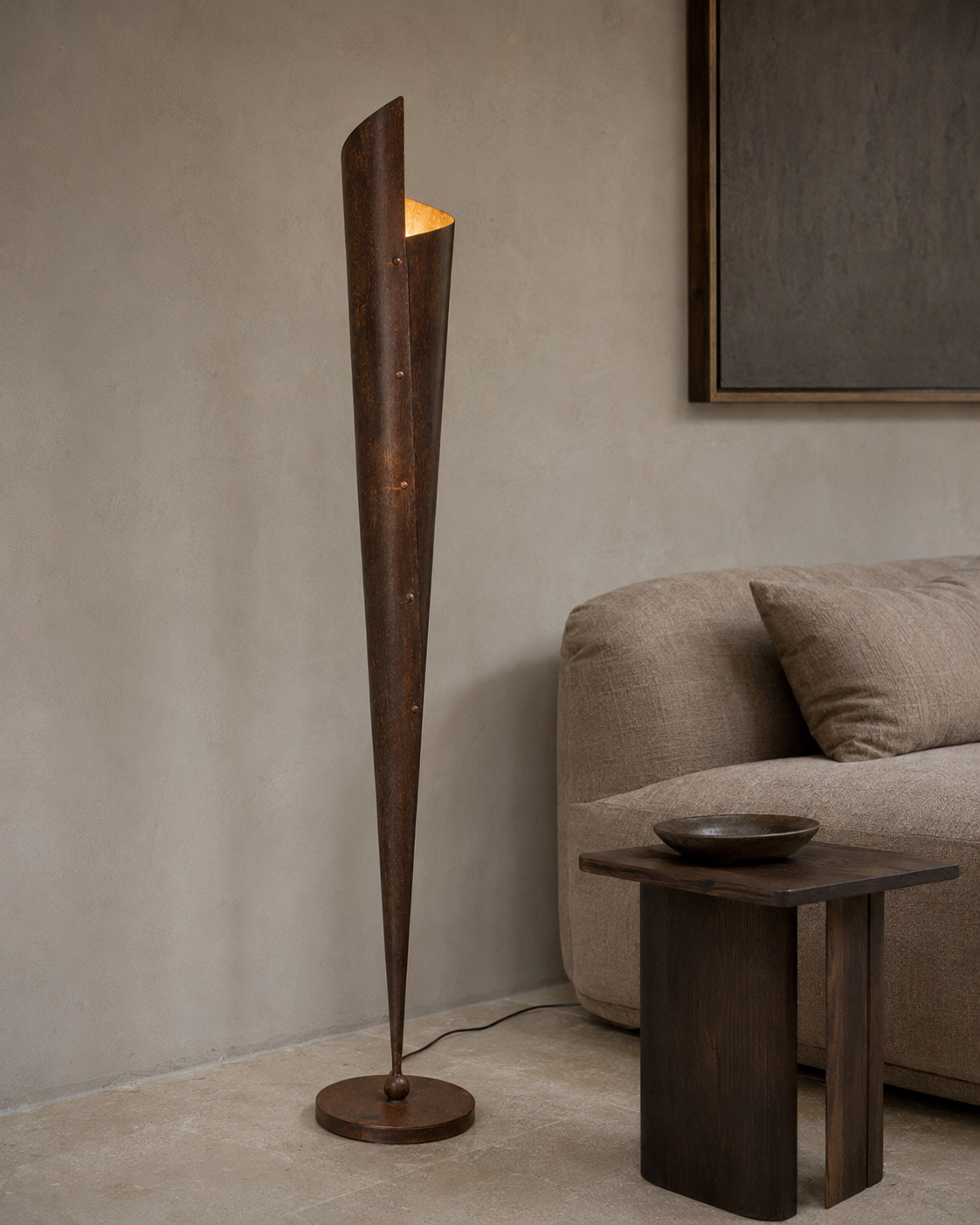 The Bonfire Floor Lamp by The Qratist features a handcrafted copper finished metal body with a sculptural tapered silhouette that emits a warm upward glow inspired by the timeless elegance of a bonfire.