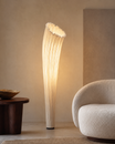 The Calla Lily Floor Lamp by The Qratist features a sculptural pleated cream white silk shade inspired by the elegant form of a blooming calla lily, creating a refined contemporary lighting statement.