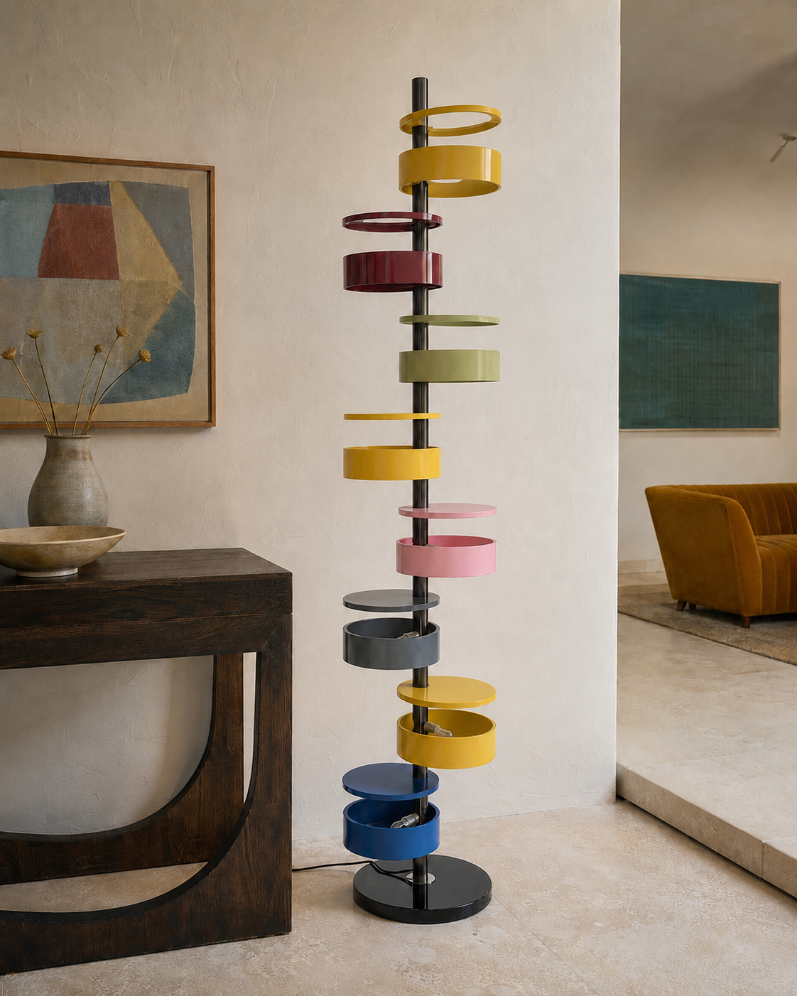 The Crayon Floor Lamp by The Qratist features colourful sculptural metal rings spiralling around a polished central column with a solid marble base, creating a playful contemporary floor lighting statement.