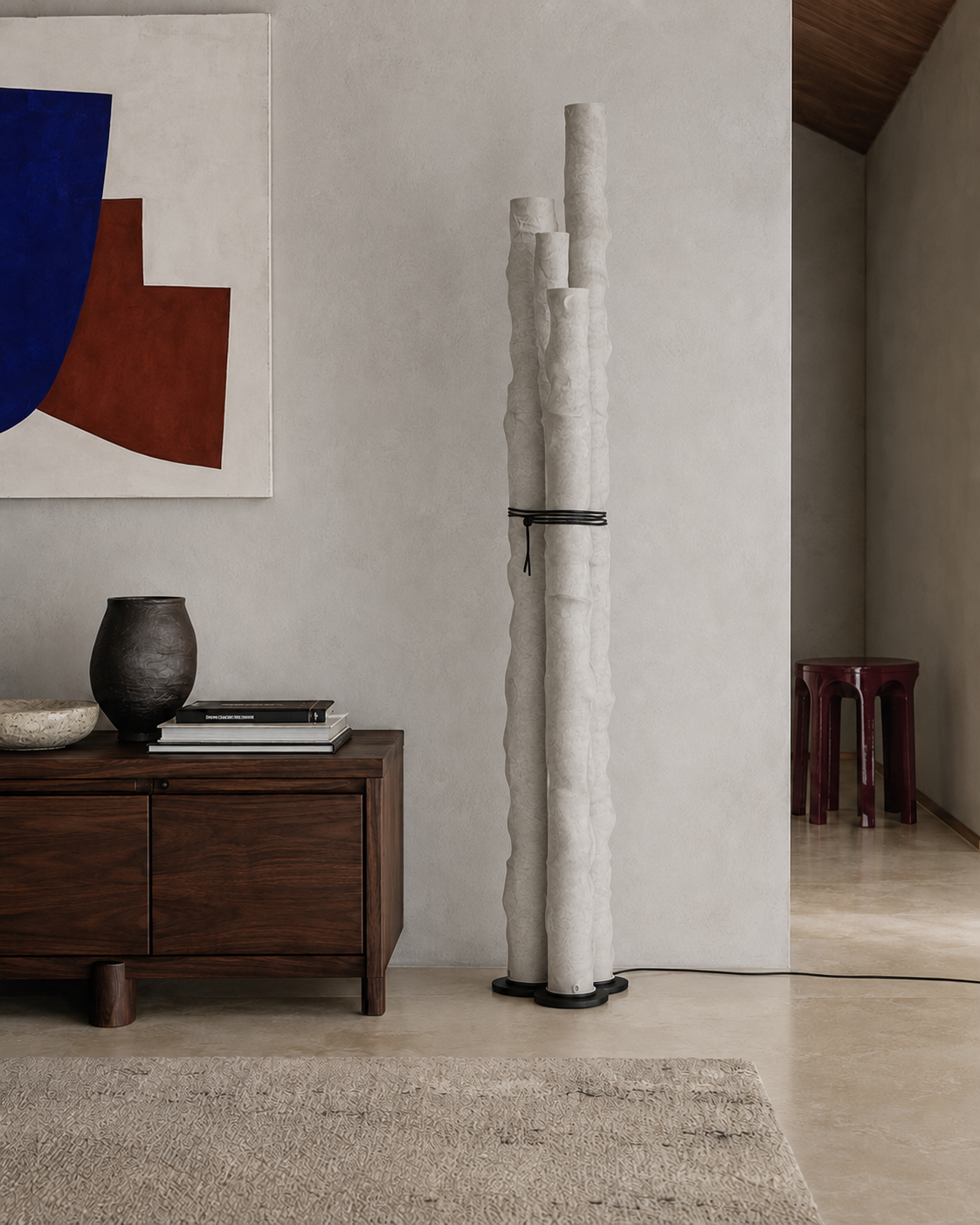 The Frosted Floor Lamp by The Qratist features handcrafted textured paper tube columns secured with a minimalist grey metal frame, creating a sculptural contemporary floor lighting statement with a warm ambient glow.
