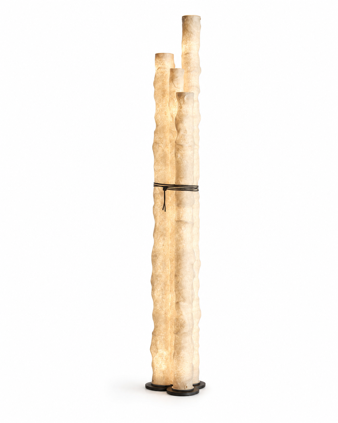 The Frosted Floor Lamp by The Qratist features handcrafted textured paper tube columns secured with a minimalist grey metal frame, creating a sculptural contemporary floor lighting statement with a warm ambient glow.