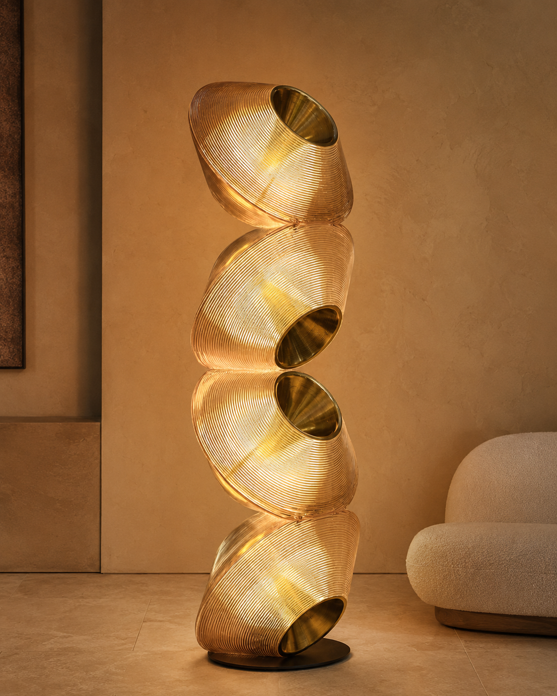 The Hourglass Floor Lamp by The Qratist features stacked sculptural recycled plastic forms with brass finished metal detailing, creating a striking architectural floor lighting statement inspired by the flowing silhouette of an hourglass.