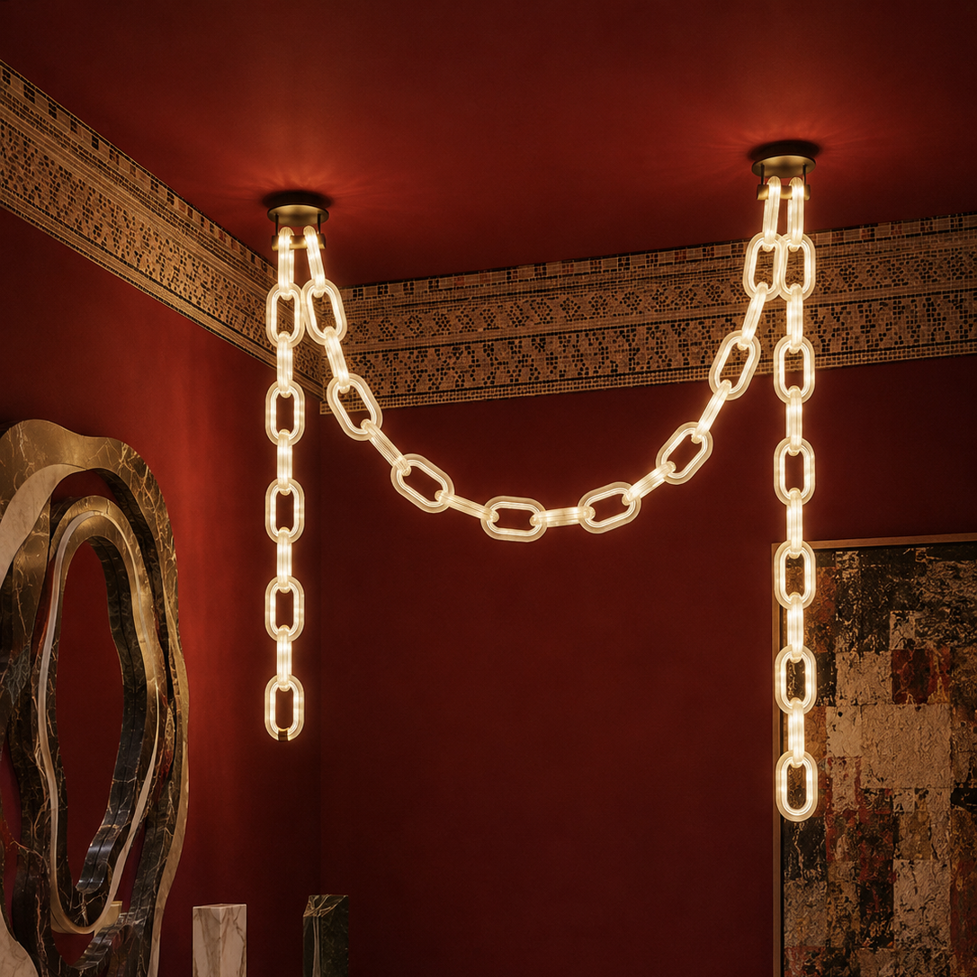 The Linked Chandelier by The Qratist features illuminated glass chain links suspended from a sleek metal frame, creating a bold contemporary architectural statement.