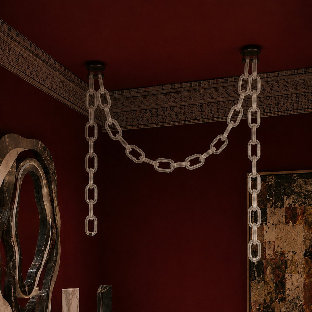 The Linked Chandelier by The Qratist features illuminated glass chain links suspended from a sleek metal frame, creating a bold contemporary architectural statement.
