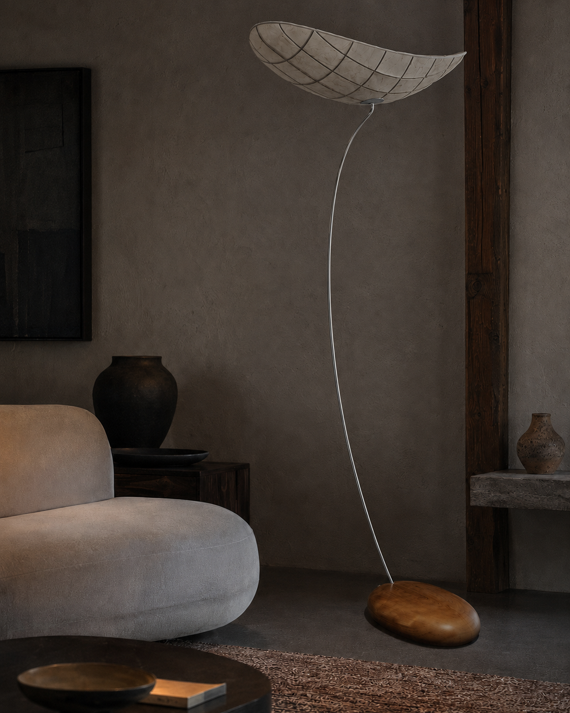 The Manta Floor Lamp by The Qratist features a handcrafted manta ray inspired fabric shade suspended on a slender metal frame with a natural wood base, creating warm ambient illumination.
